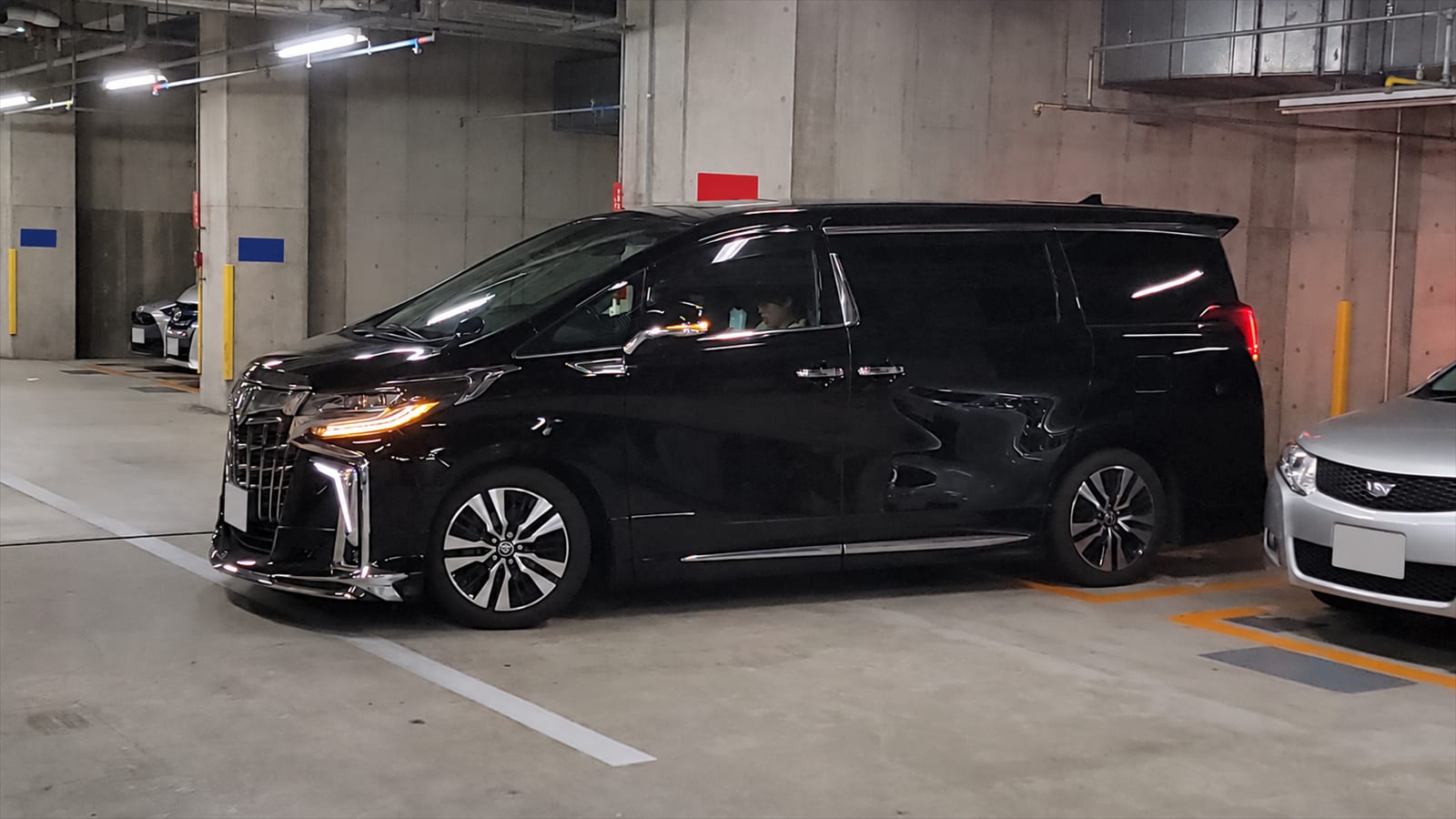 地下駐車場の黒い送迎車