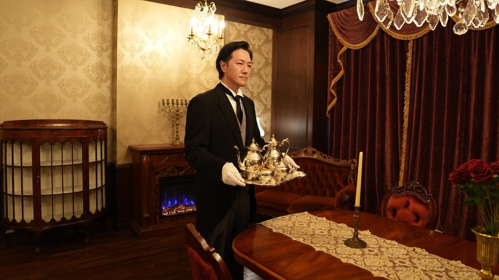 THE BUTLERの公式サイトより。お台場の執事サロンで銀のティーセットを運ぶ頭取・執事ベル