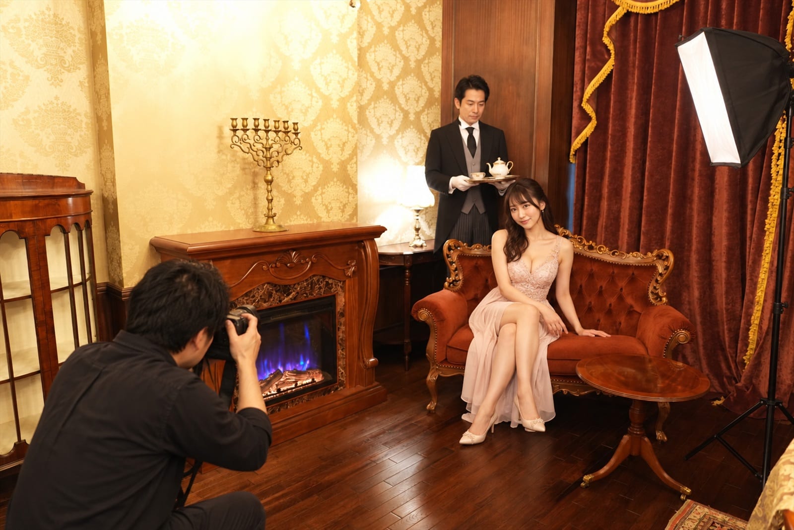 暖炉の間のソファで撮影するモデルと写真家